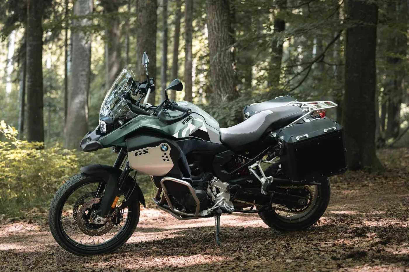 BMW F 900 GS Adventure avec valises sur un sentier en for&ecirc;t